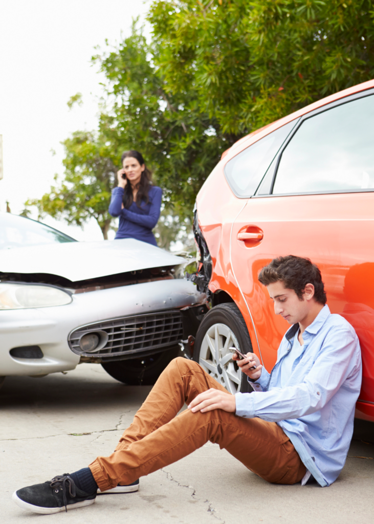 Boy sitting near car